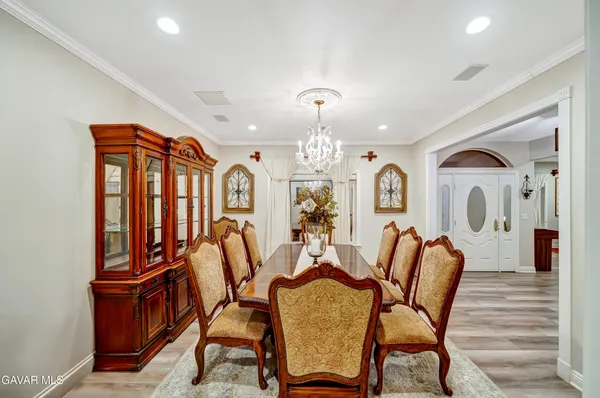 a kitchen with stainless steel appliances granite countertop a stove a refrigerator a sink a stove and white cabinets with wooden floor