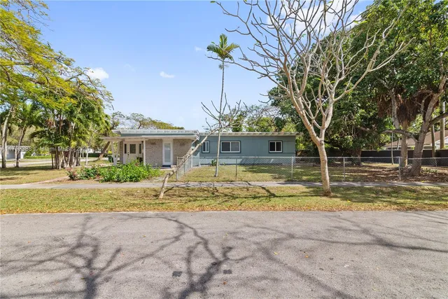 a view of a house with a big yard and large trees