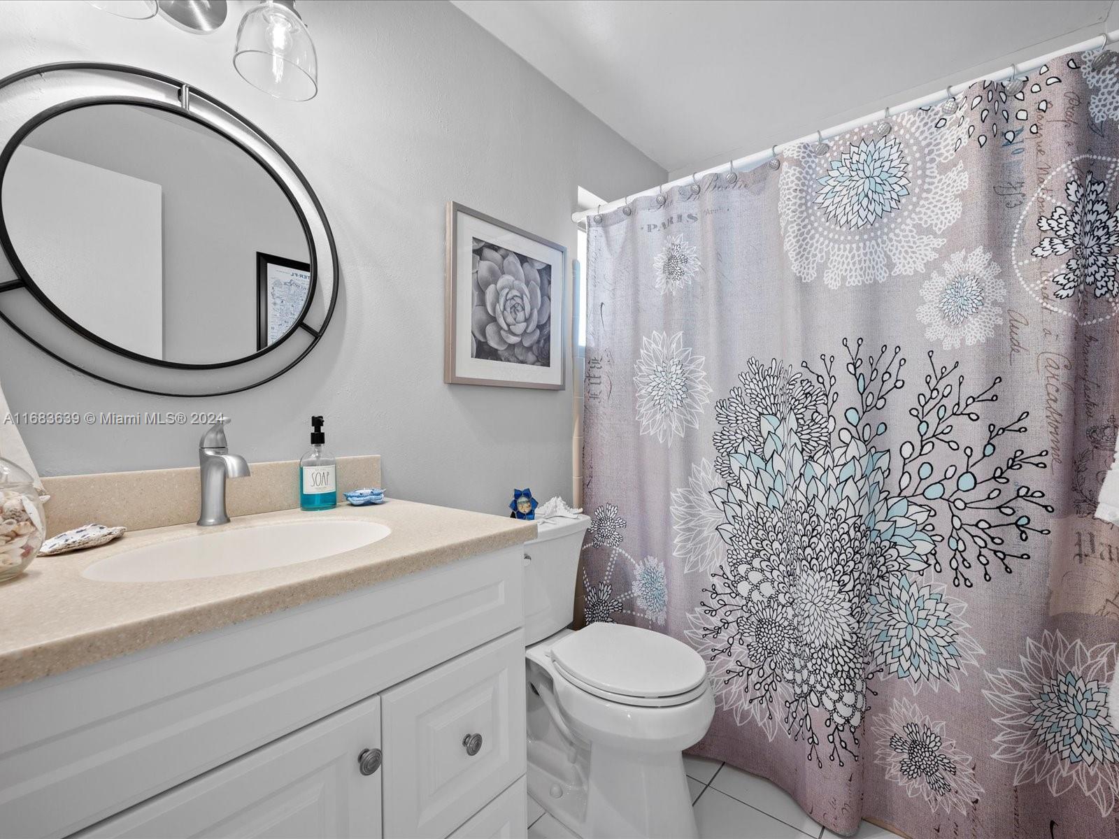 368 Church Road Tequesta, FL 33469 - Photo 14 of 20 a bathroom with a toilet a sink and a mirror