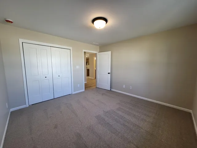 an empty room with windows and closet