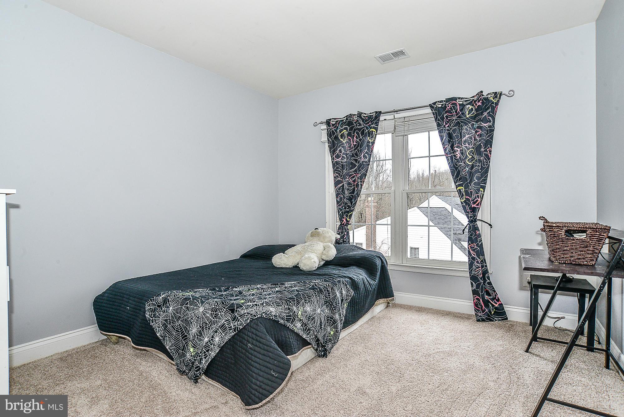 8747 Center Road Springfield, VA 22152 - Photo 21 of 30 a bedroom with a bed a chair and a chandelier