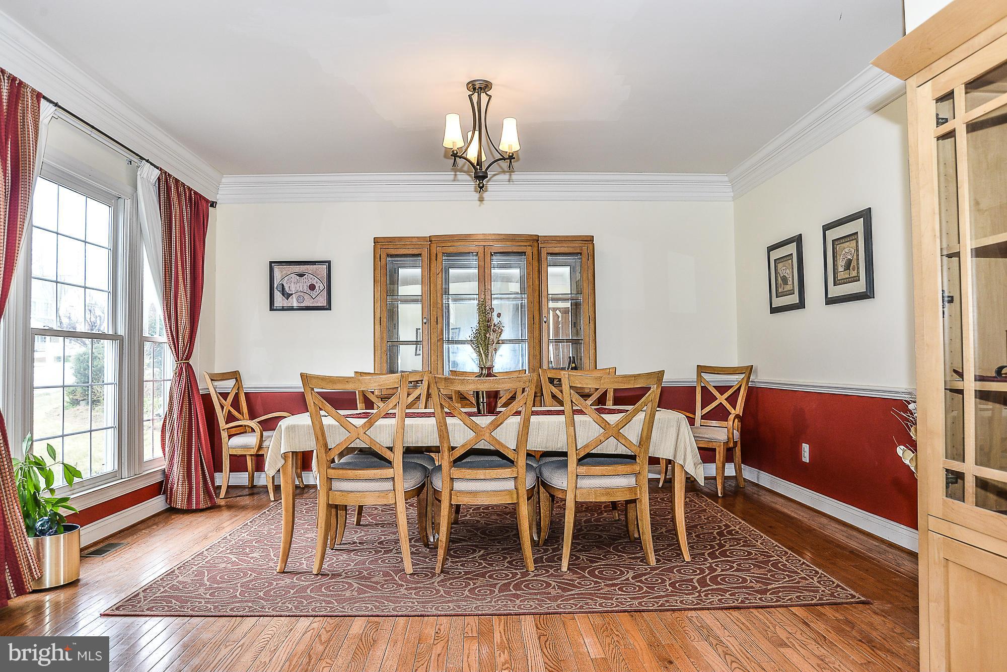 8747 Center Road Springfield, VA 22152 - Photo 8 of 30 a dining room with furniture a chandelier and wooden floor