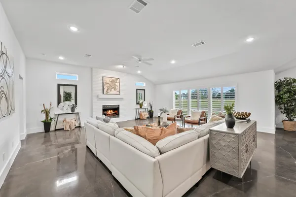 a living room with furniture large window and a fireplace