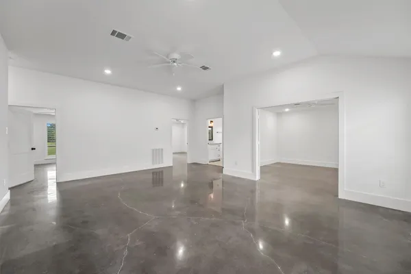 an empty room with a window and ceiling fan