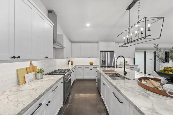 a large kitchen with stainless steel appliances granite countertop a lot of counter space