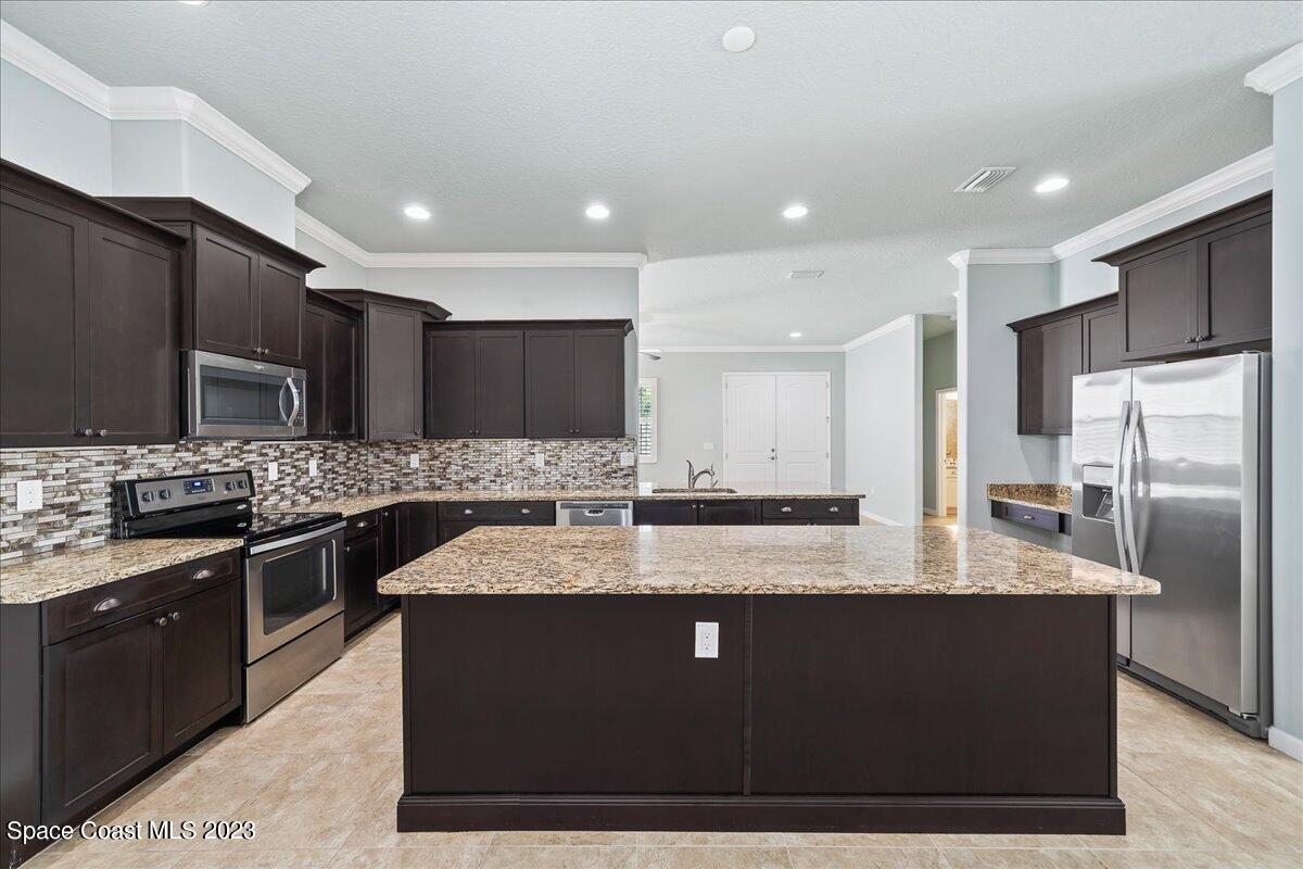 603 Heming Way Melbourne, FL 32901 - Photo 11 of 45 a large kitchen with stainless steel appliances granite countertop a granite counter tops a stove a sink and a refrigerator