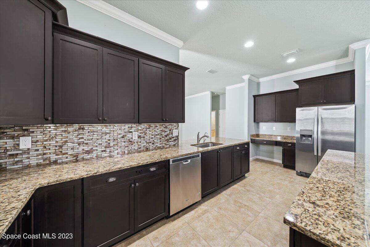 603 Heming Way Melbourne, FL 32901 - Photo 12 of 45 a kitchen with stainless steel appliances kitchen island granite countertop a sink and stove