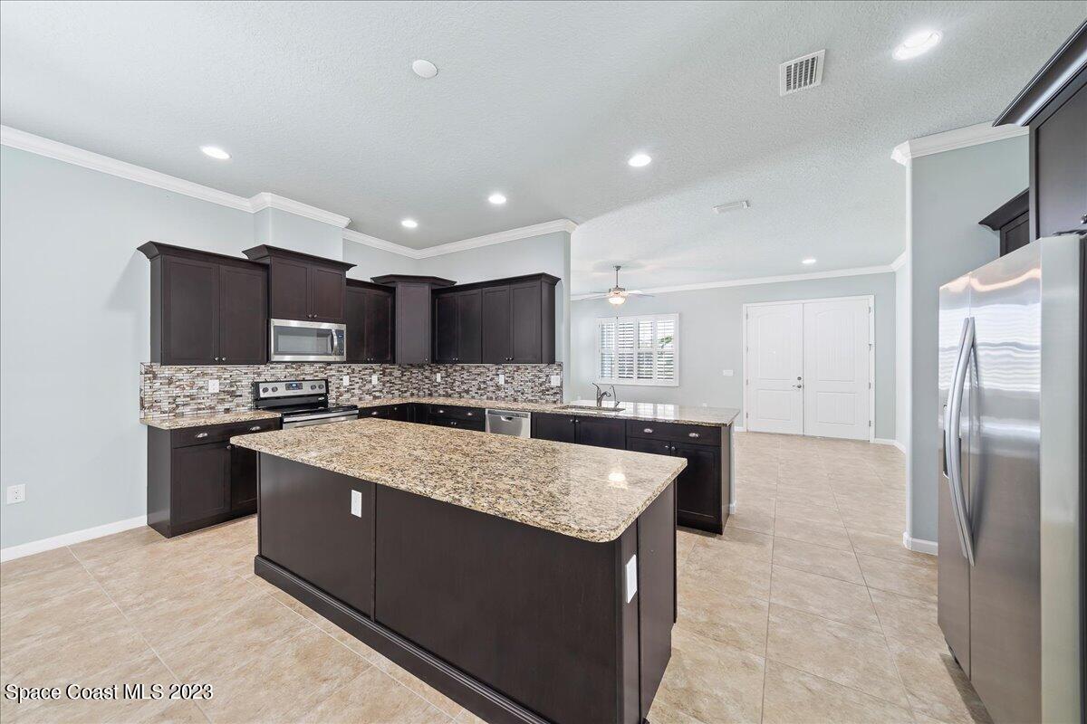 603 Heming Way Melbourne, FL 32901 - Photo 13 of 45 a large kitchen with stainless steel appliances kitchen island granite countertop a stove and a sink