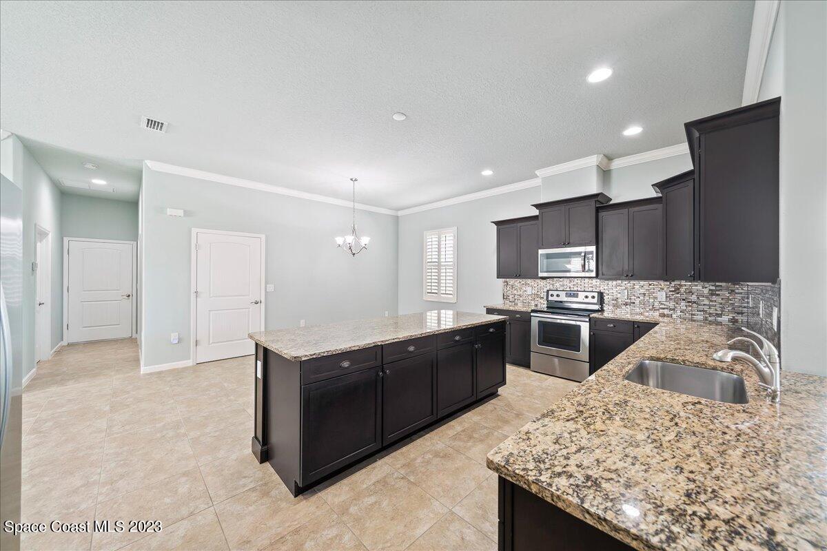 603 Heming Way Melbourne, FL 32901 - Photo 15 of 45 a kitchen with stainless steel appliances granite countertop a sink stove and refrigerator