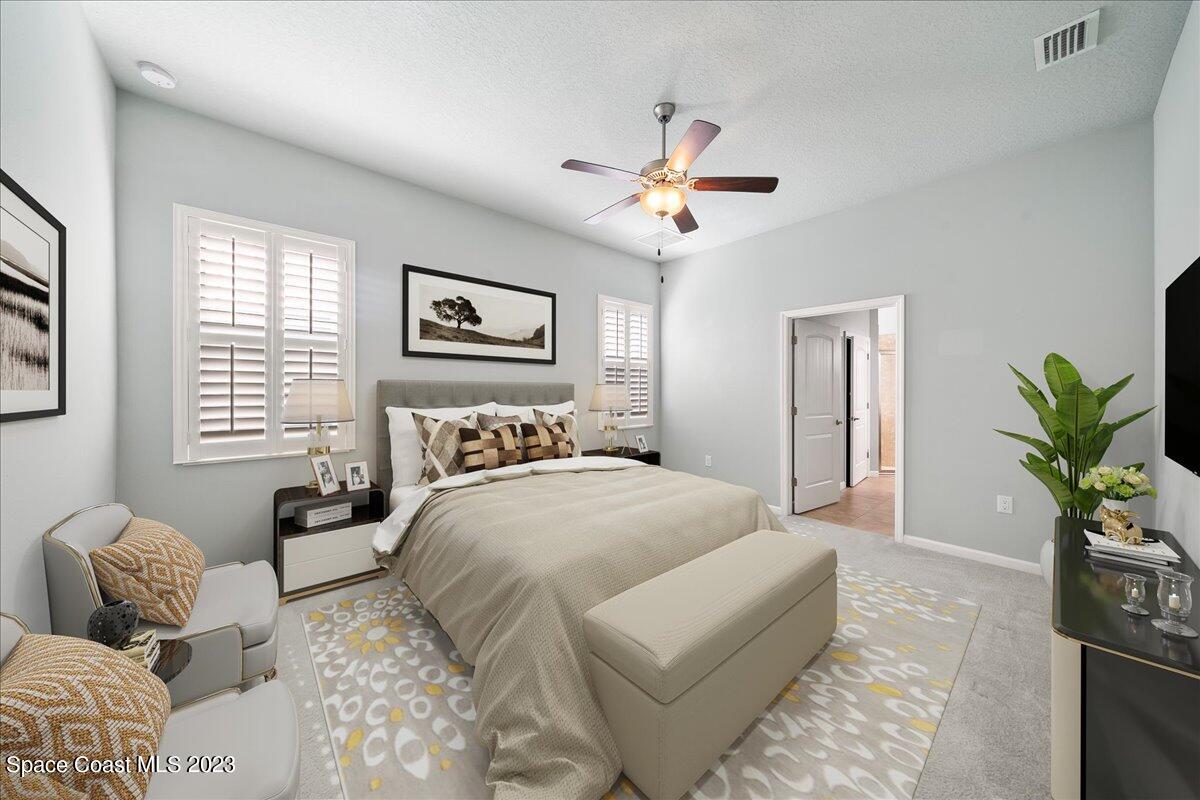 603 Heming Way Melbourne, FL 32901 - Photo 25 of 45 a spacious bedroom with a bed a couch and a potted plant