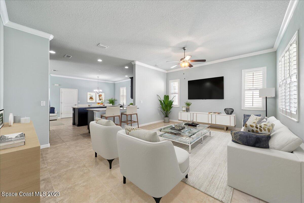 603 Heming Way Melbourne, FL 32901 - Photo 8 of 45 a living room with furniture a flat screen tv and a chandelier