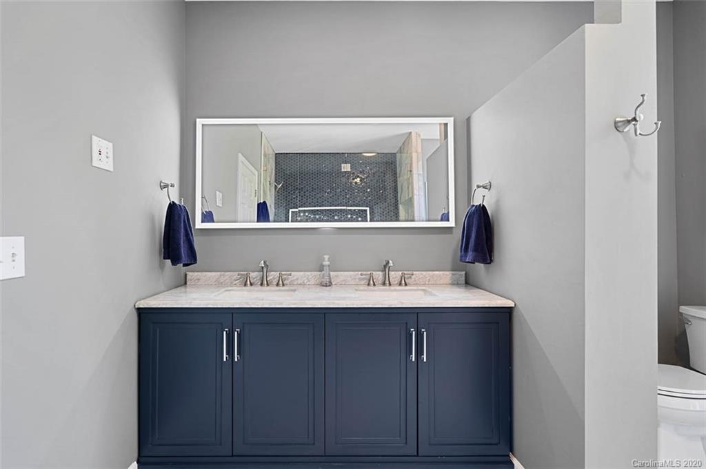 7915 Park Road Charlotte, NC 28210 - Photo 18 of 40 a hallway with a sink and a mirror