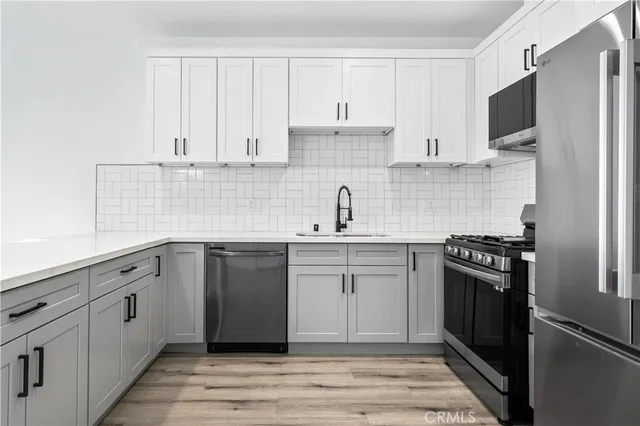 a kitchen with cabinets stainless steel appliances and sink