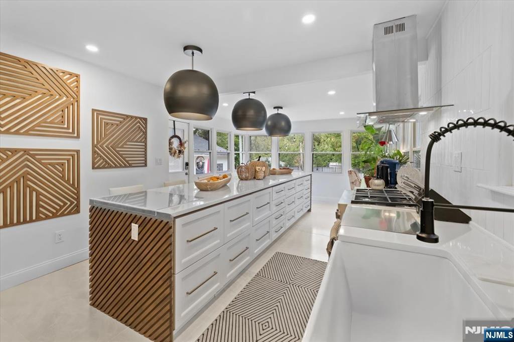 a kitchen with stainless steel appliances a sink a stove and a wooden floors