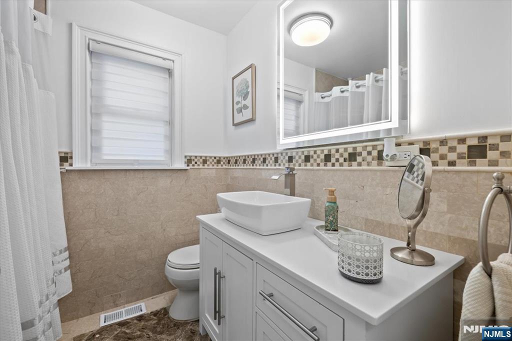338 South Van Dien Avenue Ridgewood, NJ 07450 - Photo 20 of 33 a bathroom with a sink a toilet and a mirror