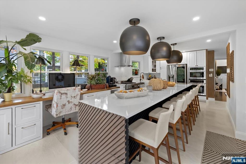 338 South Van Dien Avenue Ridgewood, NJ 07450 - Photo 4 of 33 a open kitchen with stainless steel appliances kitchen island granite countertop a table and chairs in it