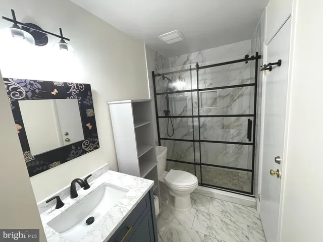 a bathroom with a sink mirror vanity and toilet