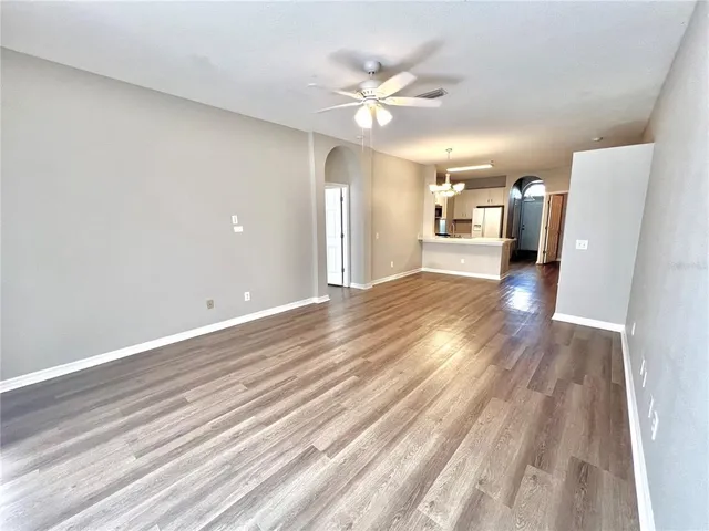 a view of a livingroom with wooden floor and a ceiling fan