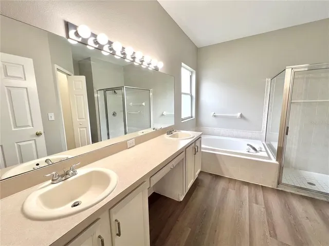 a bathroom with a granite countertop sink a large mirror and a bathtub