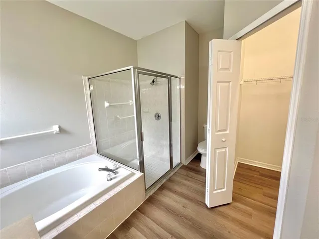 a view of bathroom with tub and shower