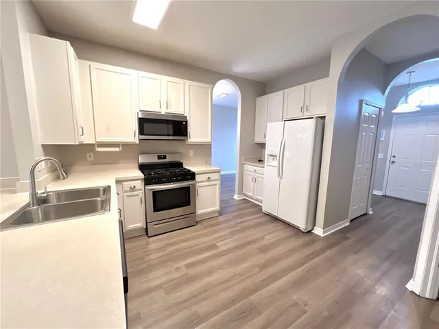 a kitchen with a refrigerator a stove a sink and a microwave