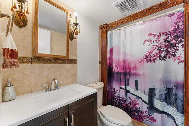 a bathroom with a sink vanity mirror and toilet