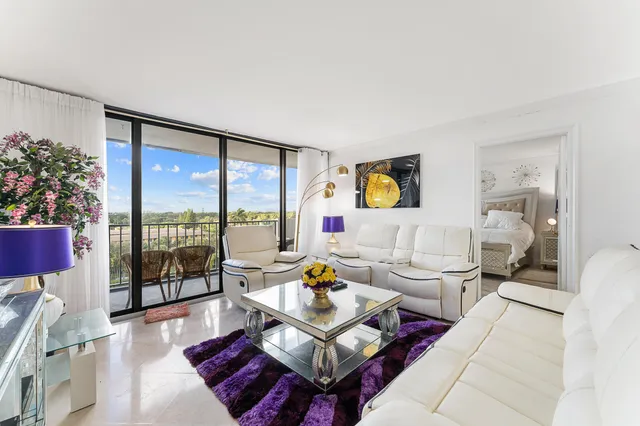 a living room with furniture and a floor to ceiling window