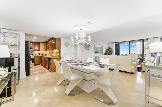 a living room with fireplace furniture and a view of kitchen