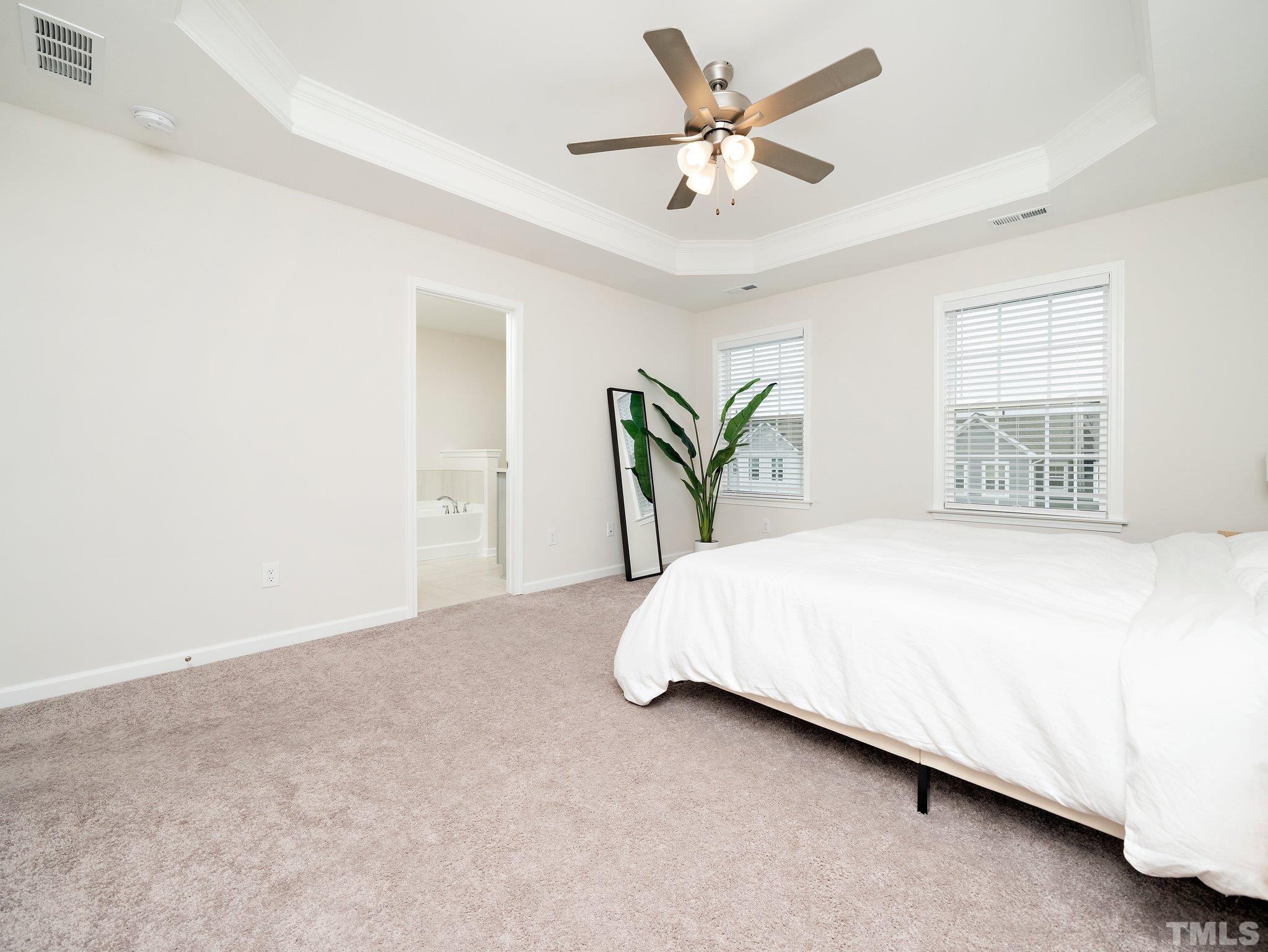 5915 Kayton Street Raleigh, NC 27616 - Photo 15 of 26 a bedroom with a bed and a chandelier