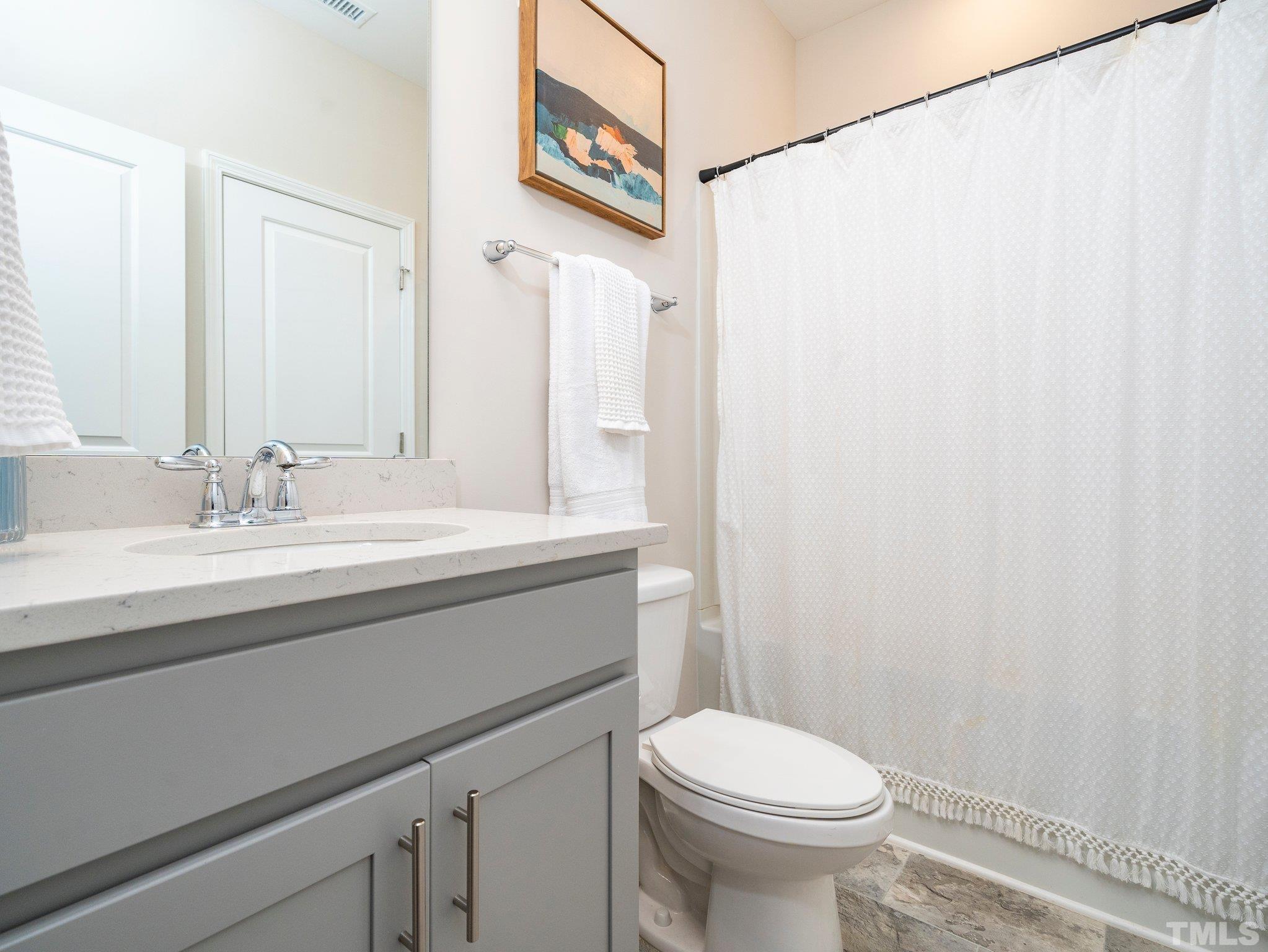 5915 Kayton Street Raleigh, NC 27616 - Photo 21 of 26 a bathroom with a sink a toilet and a mirror