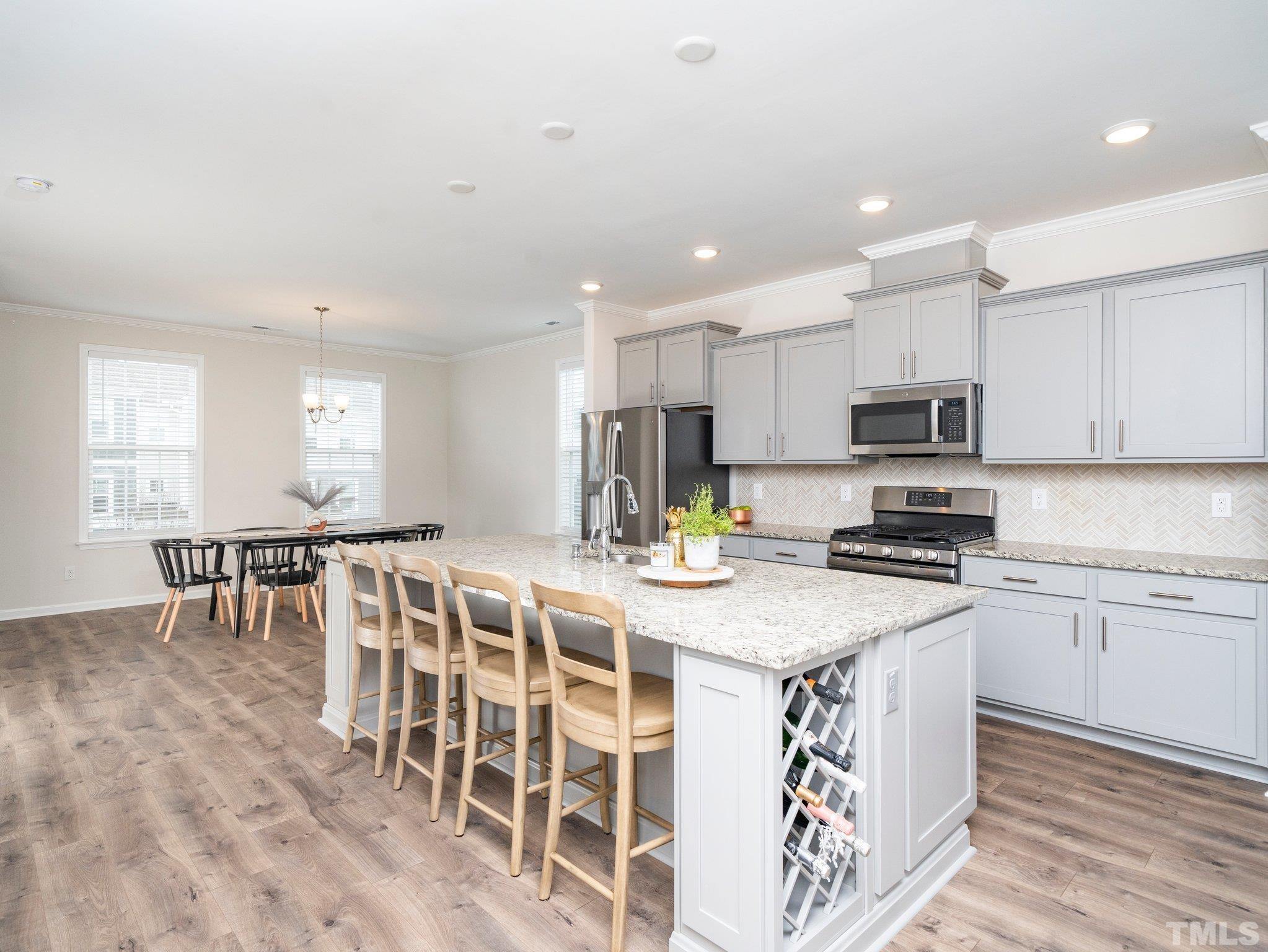 5915 Kayton Street Raleigh, NC 27616 - Photo 5 of 26 a kitchen with stainless steel appliances granite countertop a stove top oven a sink a dining table and chairs