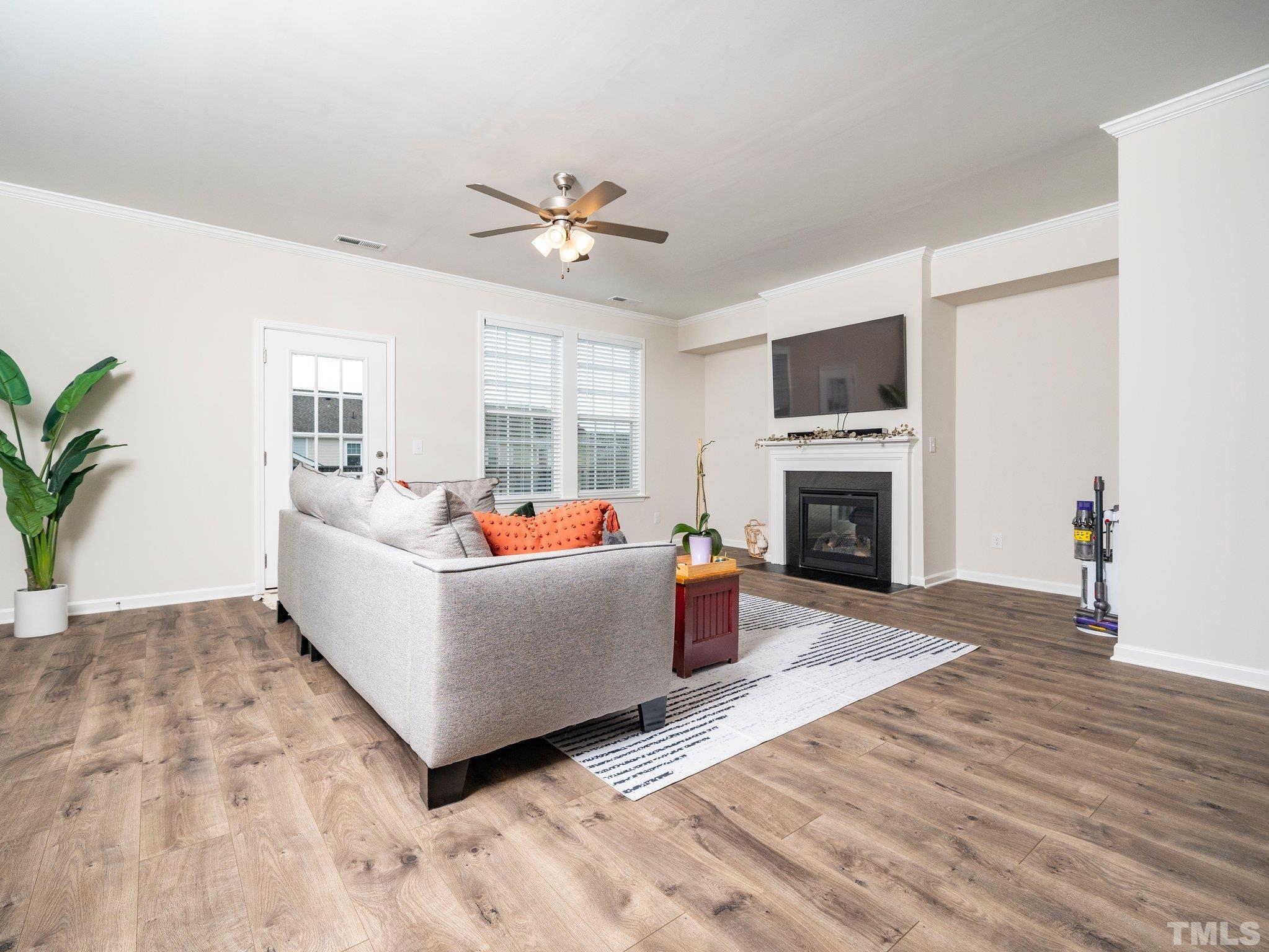 5915 Kayton Street Raleigh, NC 27616 - Photo 7 of 26 a living room with furniture a fireplace and a flat screen tv