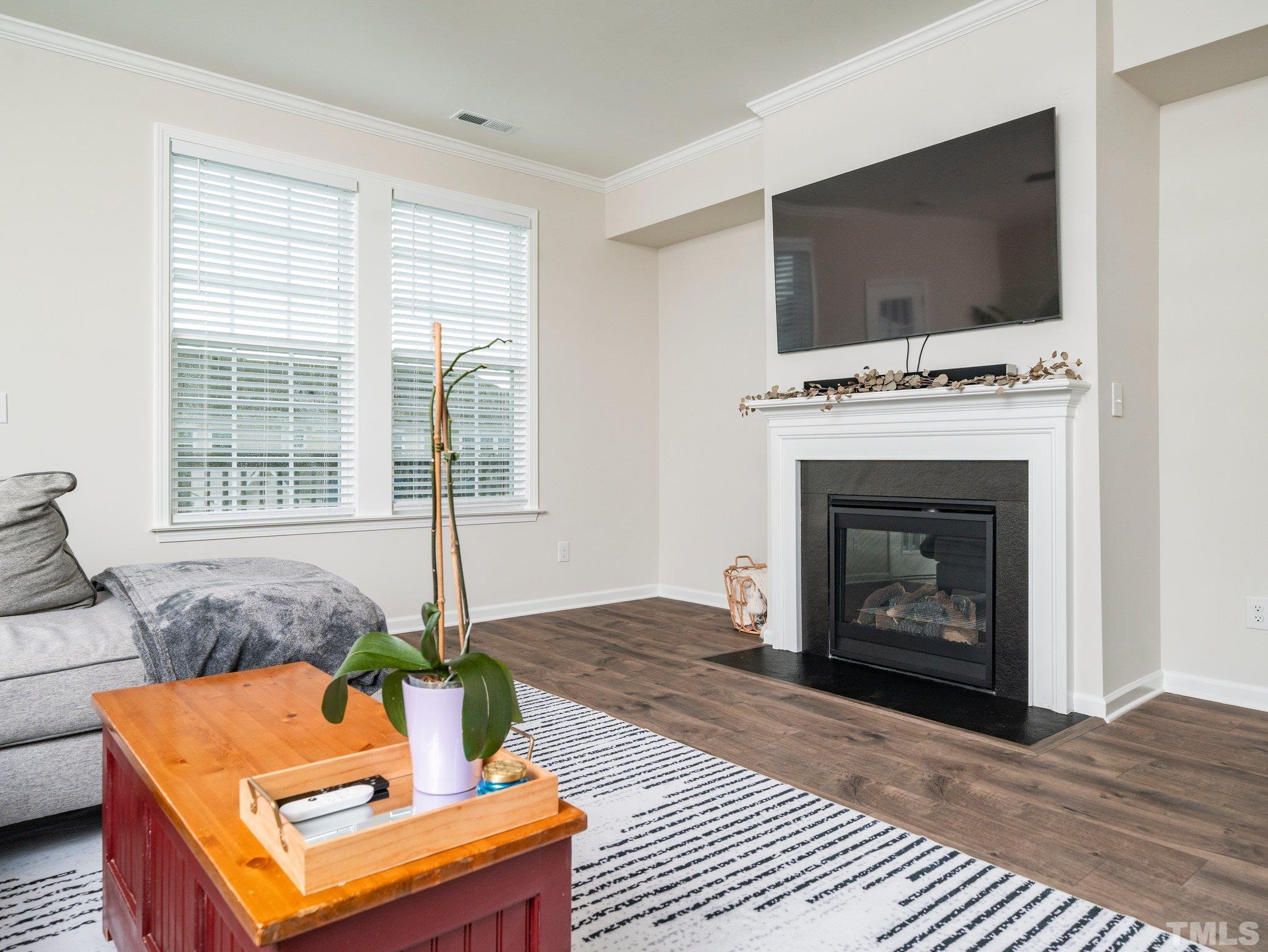 5915 Kayton Street Raleigh, NC 27616 - Photo 8 of 26 a living room with furniture a flat screen tv and a fireplace