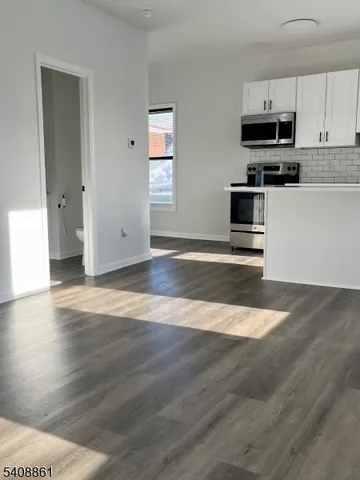 a kitchen with granite countertop a stove and a microwave