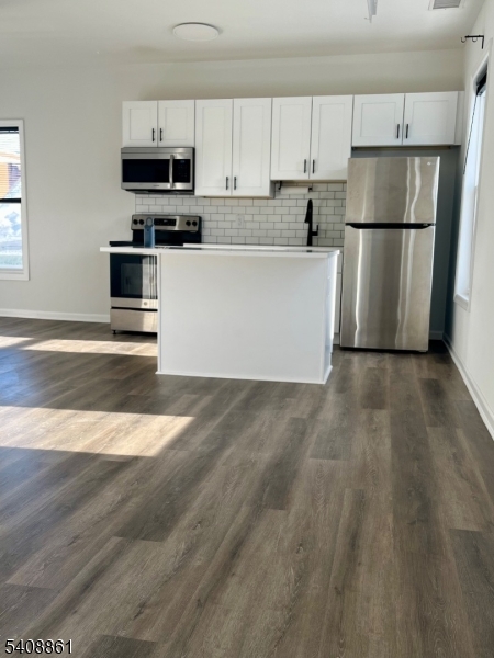 53 High Street, Unit A Newton, NJ 07860 - Photo 7 of 13 a kitchen with kitchen island a white counter top space cabinets and stainless steel appliances