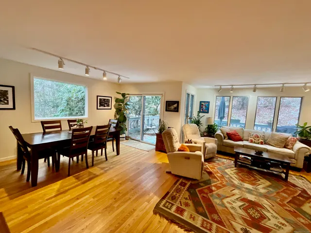 a living room with furniture wooden floor and a floor to ceiling window