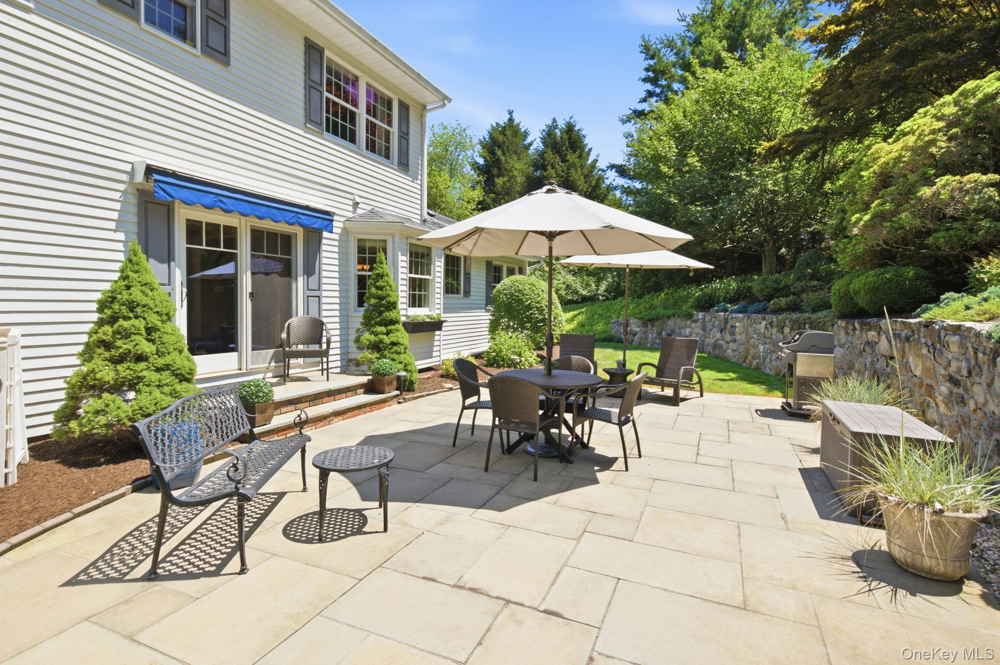 32 Bedell Road Katonah, NY 10536 - Photo 32 of 49 Sized for a crowd, the patio unfolds beneath market umbrellas with terraced plantings rising behind.