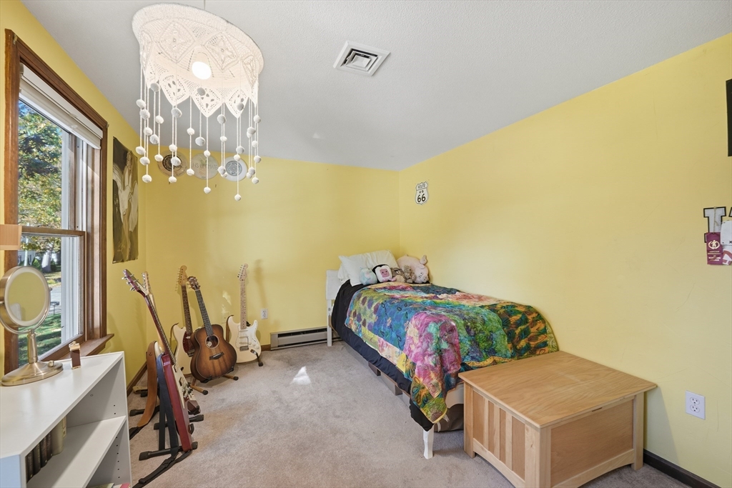 5 Ferncroft Street Longmeadow, MA 01106 - Photo 28 of 40 a bedroom with a bed and a chandelier