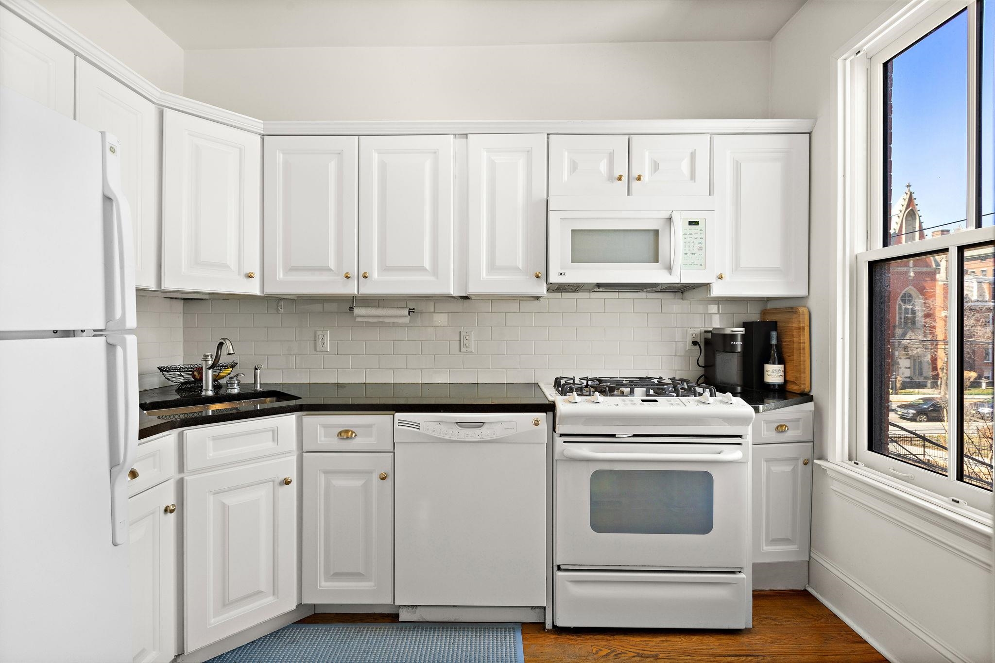 259 4th Street, Unit 2 Hoboken, NJ 07030 - Photo 12 of 20 a kitchen with white cabinets and white appliances