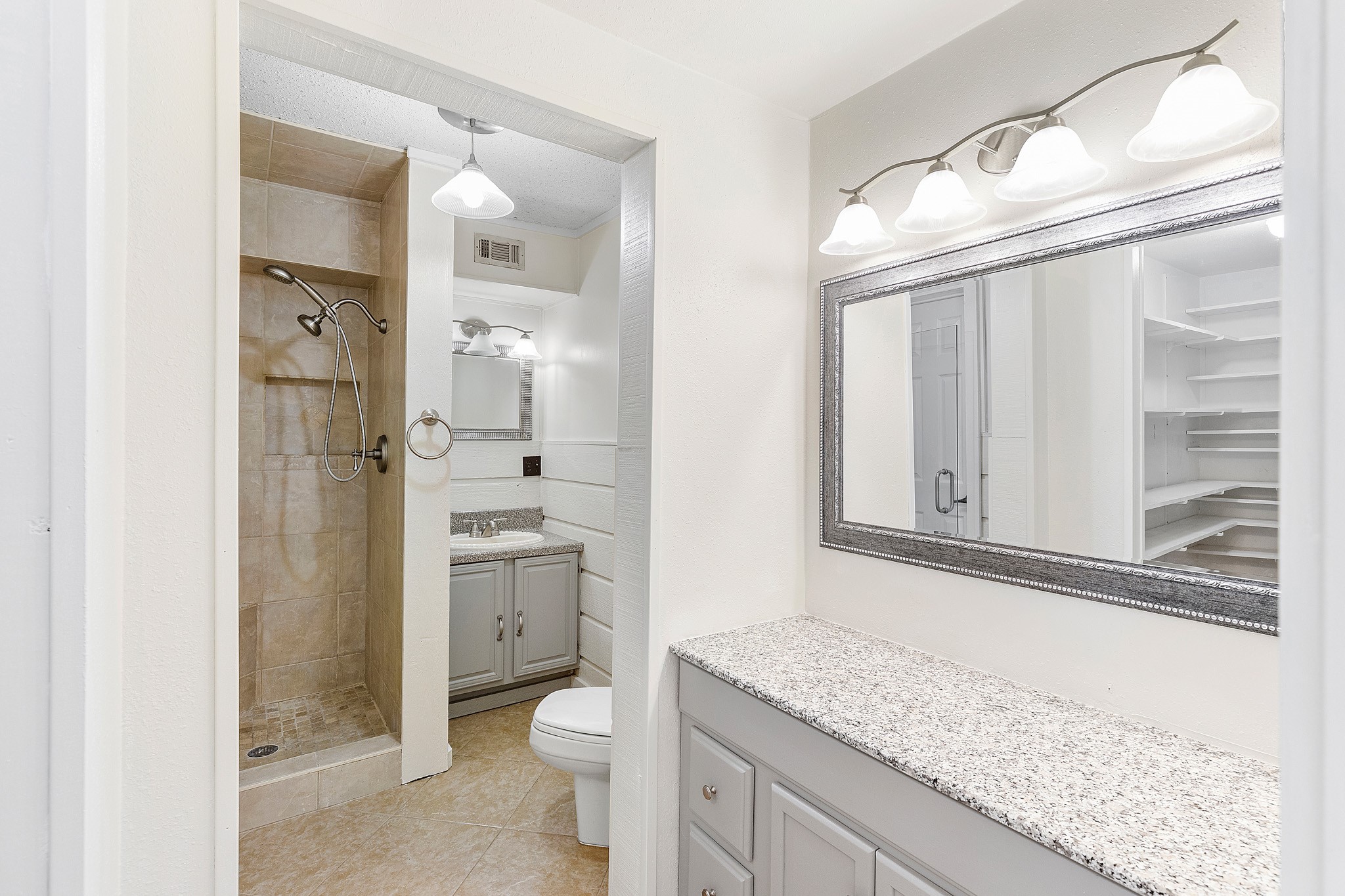 230 Walnut Drive Trinity, TX 75862 - Photo 15 of 48 The ensuite bath is thoughtfully designed with both comfort and convenience in mind, featuring a stand-up shower with a built-in seat for a spa-like experience. A separate vanity area offers a dedicated space for your daily routine, while a walk-in linen closet keeps essentials neatly organized and close at hand.