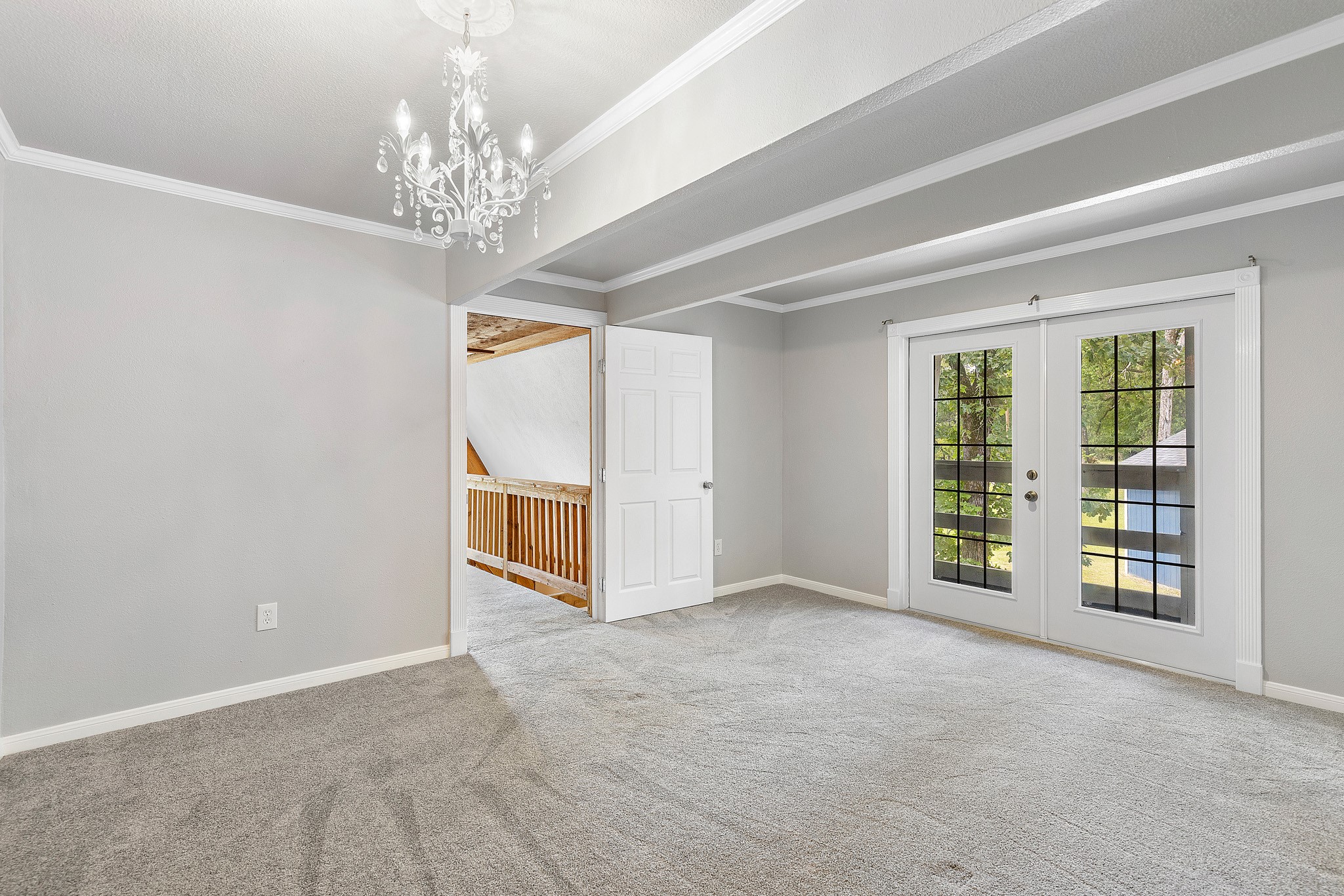 230 Walnut Drive Trinity, TX 75862 - Photo 18 of 48 Generously sized secondary bedroom features a chandelier and French doors that open to the front balcony!