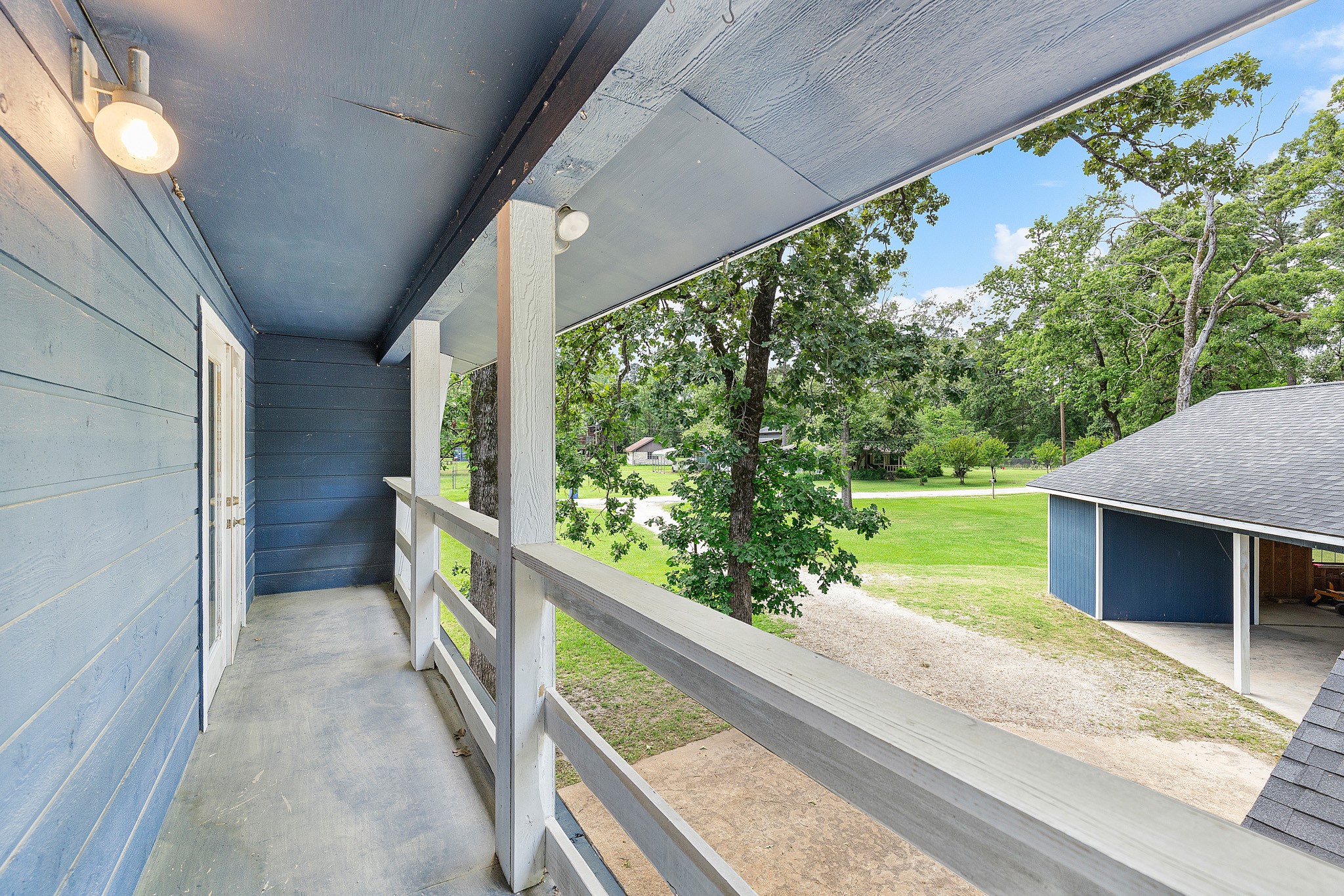 230 Walnut Drive Trinity, TX 75862 - Photo 20 of 48 Upstairs, the secondary bedrooms share access to a charming front porch balcony—a perfect spot to enjoy morning sunshine, evening breezes, or simply take in the view. This thoughtful outdoor touch adds character and a sense of retreat to the upper level.