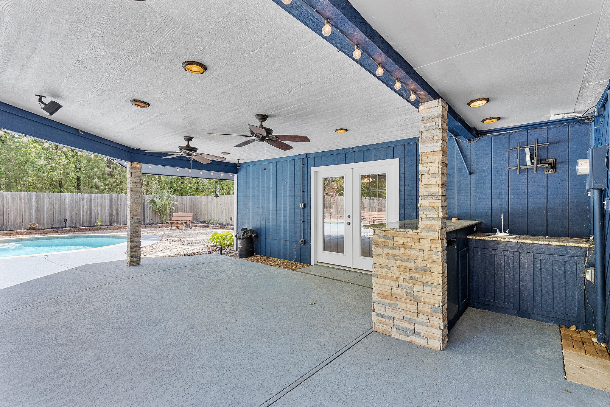 230 Walnut Drive Trinity, TX 75862 - Photo 28 of 48 Enjoy year-round outdoor living on the expansive covered patio overlooking the sparkling pool—perfect for relaxing in the shade, dining al fresco, or hosting unforgettable gatherings. This seamless connection between indoor comfort and outdoor luxury makes entertaining a breeze.