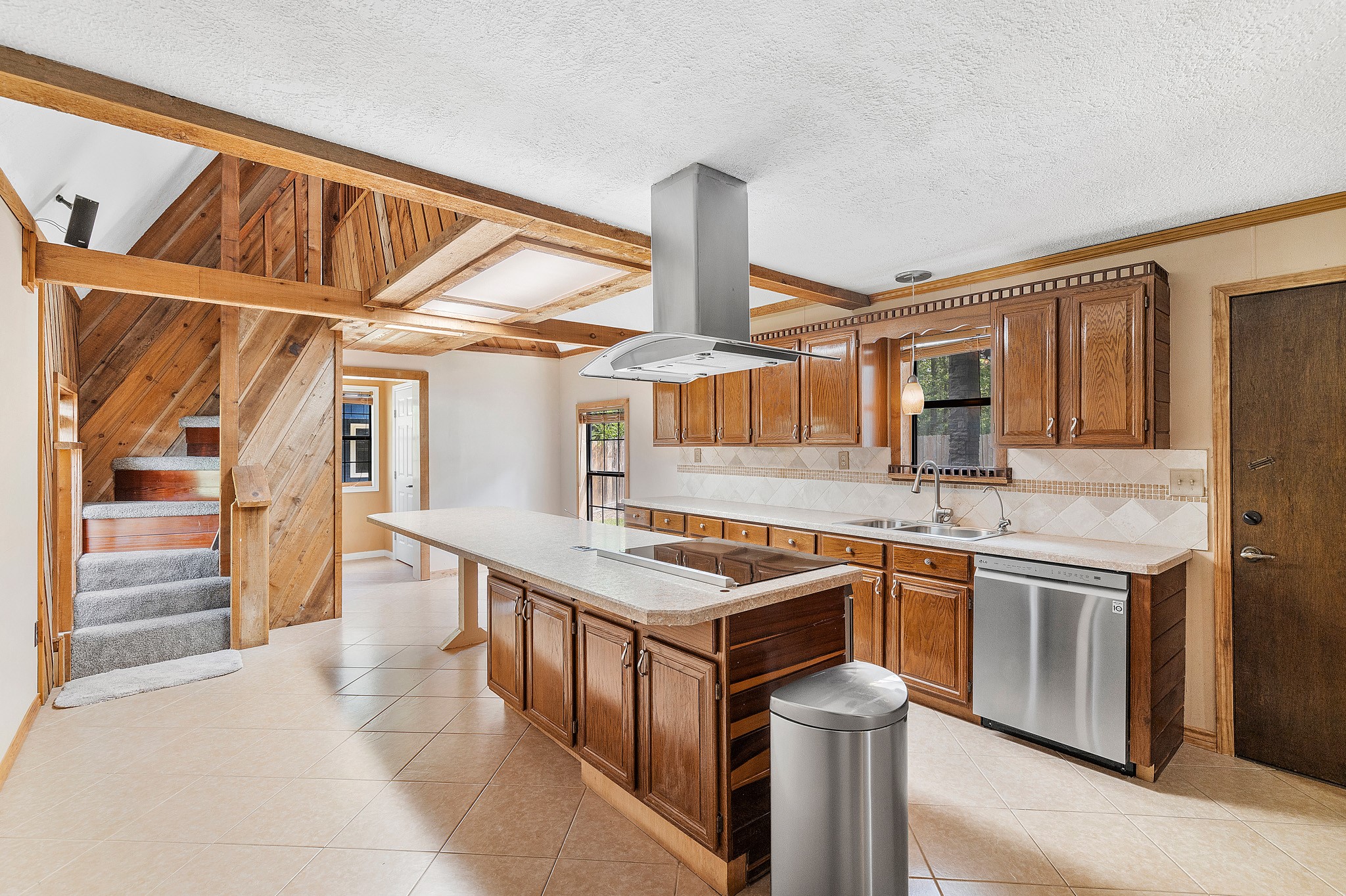 230 Walnut Drive Trinity, TX 75862 - Photo 7 of 48 Cook, gather, and create in this beautifully designed kitchen tailored for both everyday living and entertaining. Anchored by a premium Bosch stove, this culinary space boasts a massive island—ideal for meal prep, casual dining, or hosting guests. You'll love the abundance of cabinet and counter space, offering both style and storage in equal measure. A spacious walk-in pantry keeps everything organized and within reach!