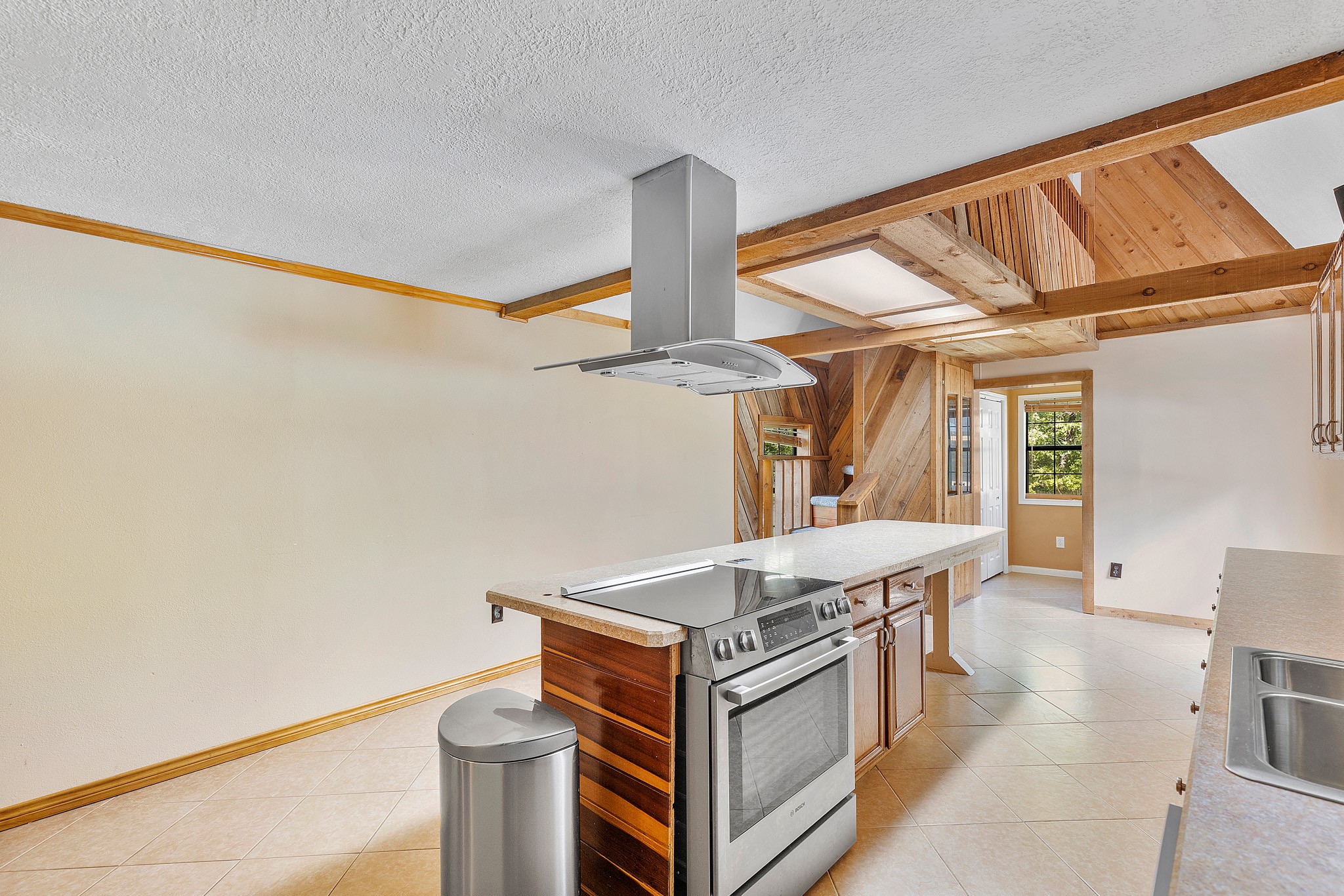230 Walnut Drive Trinity, TX 75862 - Photo 8 of 48 An alternate view of the kitchen reveals even more thoughtful design elements—a convenient utility room and half bath tucked just beyond, perfect for busy households. Look up, and you'll notice the catwalk at the top of the stairs, offering a striking architectural detail and a glimpse of the home's open, connected layout.