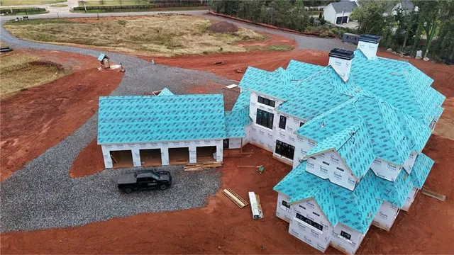 an aerial view of a house with a yard and a large tree