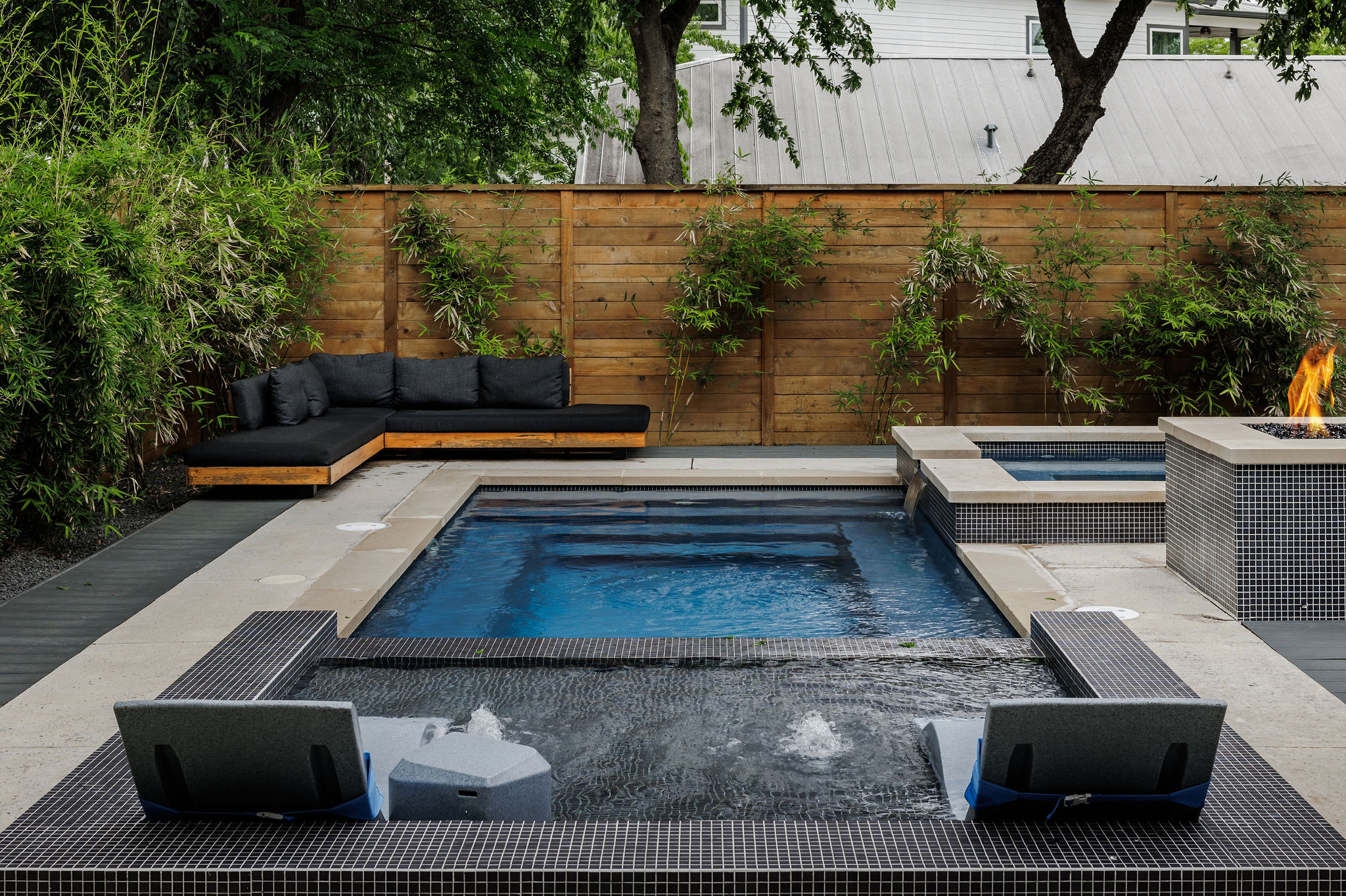 1605 Maple Avenue Austin, TX 78702 - Photo 2 of 33 Outdoor living space featuring a rectangular swimming pool, integrated spa with mosaic tile, and a fire pit with stone coping