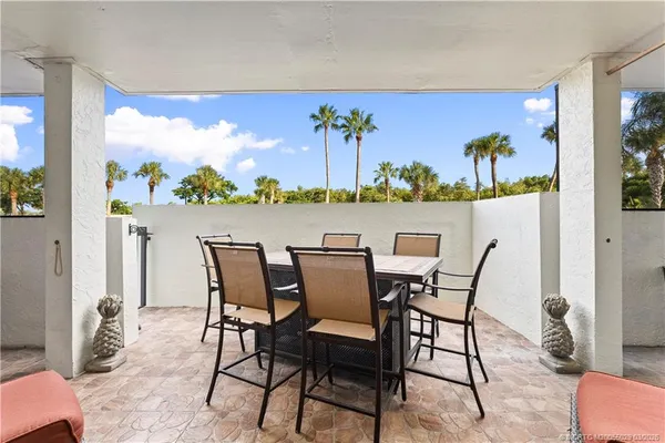 a dining room with wooden floor a chandelier a glass table and chairs