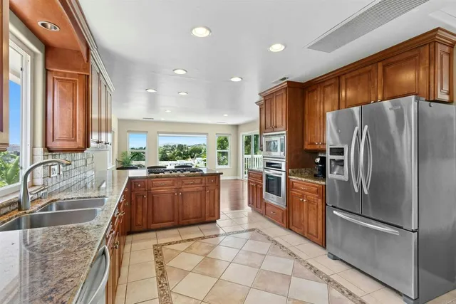 a kitchen with stainless steel appliances granite countertop a refrigerator and a sink