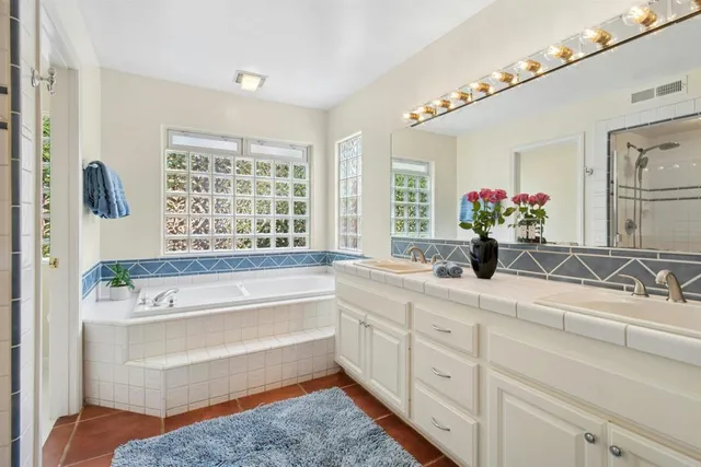 a bathroom with a tub sink and mirror